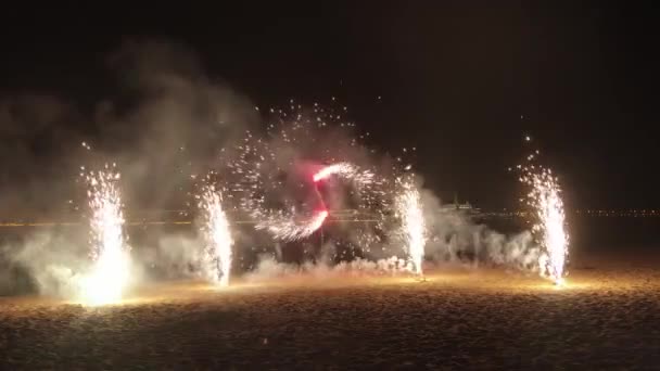 Esplosione di fuochi d'artificio sulla spiaggia della città di notte - movimenti rotanti ed esplosioni verso l'alto — Video Stock