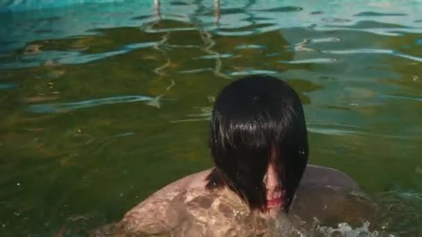 Joven saltando del agua y quita el pelo de la cara — Vídeos de Stock