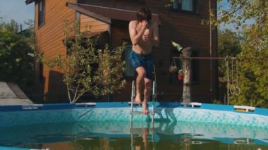 Genç adam şişme havuza atlıyor.