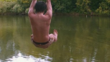 Genç adam sopayla sallanıyor ve nehre düşüyor.