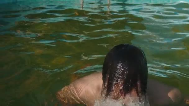 Joven saltando del agua y sacando el pelo del agua — Vídeo de stock