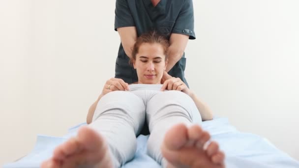 Giovane donna sdraiata su un divano - il massaggiatore che preme sulle spalle — Video Stock