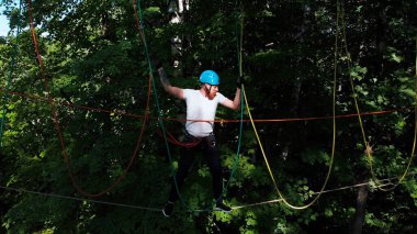 İp macerası - adam ağaca bağlı askı ipinde yürür