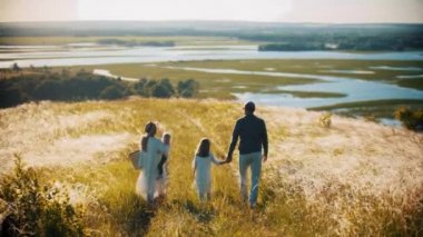 Dört kişilik bir aile su kenarındaki buğday tarlasına doğru yürüyorlar.