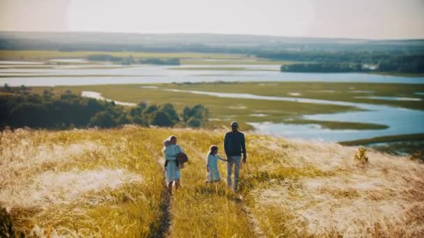 Familia de cuatro miembros en el camino en el campo de trigo — Vídeo de stock