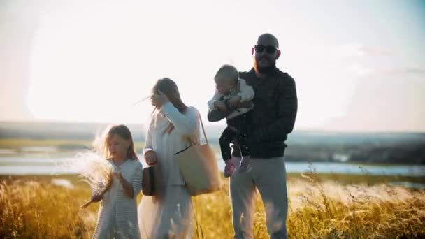 Giovane famiglia in piedi sul campo di grano - padre che tiene un piccolo bambino — Video Stock