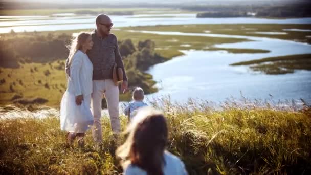 Uma menina correndo para sua família no campo de trigo — Vídeo de Stock