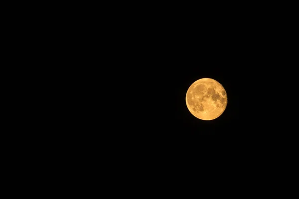 Jasnożółty księżyc w ciemnym, prawie czarnym niebie — Zdjęcie stockowe