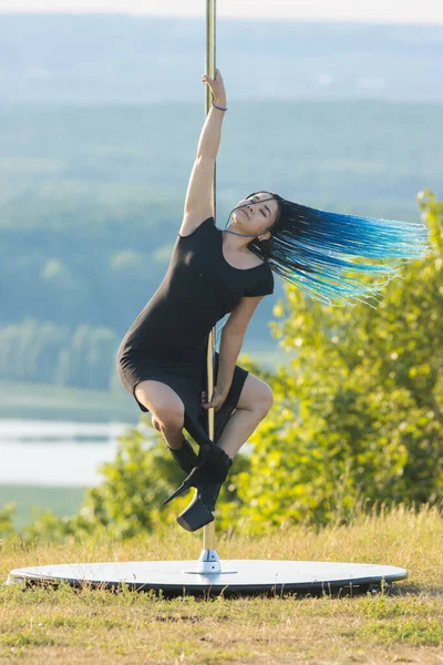 Mujer con trenzas azules en tacones altos bailando junto al poste al aire libre —  Fotos de Stock