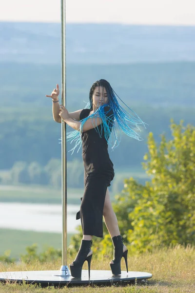 Sexy woman dancer with blue braids standing by the pole — Stock Photo, Image