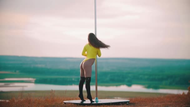 Frau im gelben Badeanzug tanzt an der Stange — Stockvideo