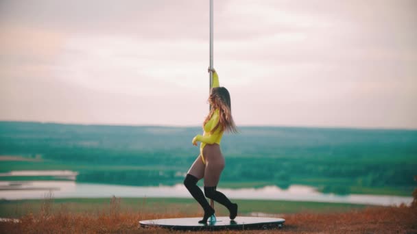 Femme en maillot de bain jaune dansant près du poteau - tournant à côté du poteau — Video