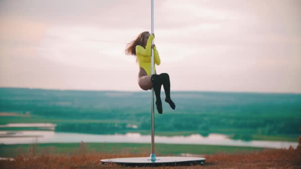 Woman in yellow swimsuit jumping on the pole — Stock Video