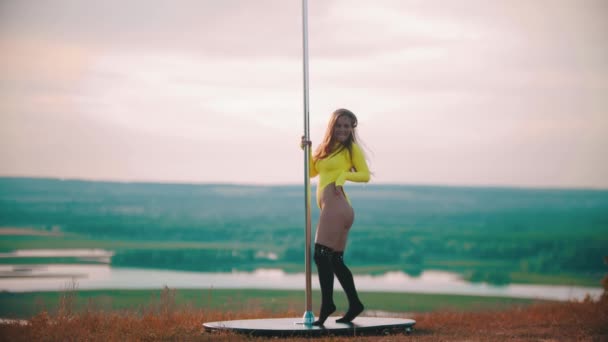 Woman in yellow swimsuit dancing by the pole with her butt — Stockvideo