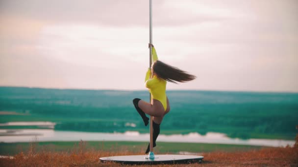 Mujer de pelo largo en traje de baño amarillo bailando junto al poste — Vídeos de Stock