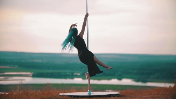 Femme en robe longue avec des tresses bleues tournant sur le poteau — Video