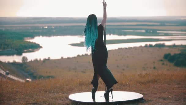 Mujer de plástico con trenzas azules en tacones altos bailando junto al poste al aire libre — Vídeos de Stock