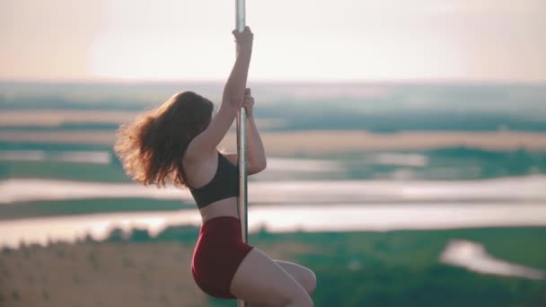 Frau in Sportkleidung tanzt an der Stange — Stockvideo