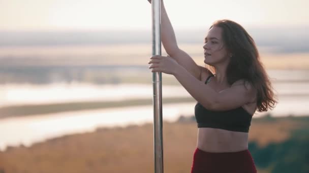 Jovem mulher em roupas esportivas dançando pelo poste — Vídeo de Stock