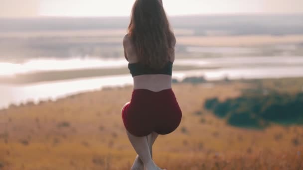 Jeune femme danseuse en vêtements de sport tenant par le poteau — Video