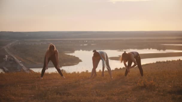 Drie jonge vrouwen doen fitness oefeningen buiten — Stockvideo