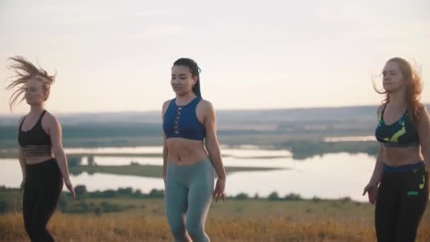 Drei junge Frauen bei Aerobic-Übungen im Freien - auf einer Stelle springen — Stockvideo