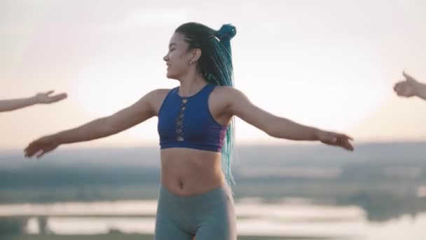 Dos jóvenes mujeres sonrientes haciendo ejercicios aeróbicos al aire libre - saltando en un lugar — Vídeos de Stock