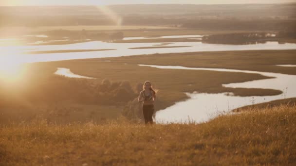 Giovane donna sportiva che corre sul campo al tramonto — Video Stock