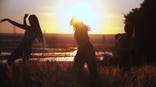 Tres mujeres jóvenes bailando lentamente al atardecer — Vídeos de Stock