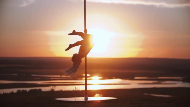 Ung kvinna hoppar på dansstången vid solnedgången — Stockvideo