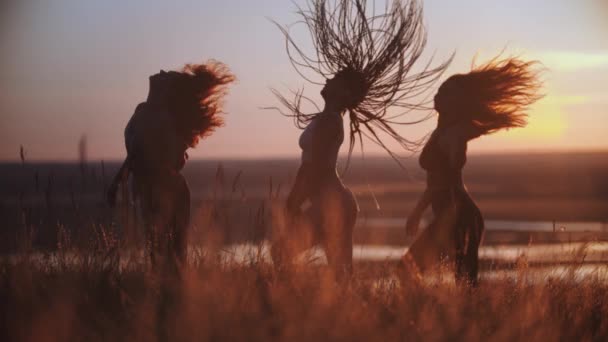 Tres mujeres jóvenes haciendo movimientos aeróbicos al atardecer — Vídeos de Stock