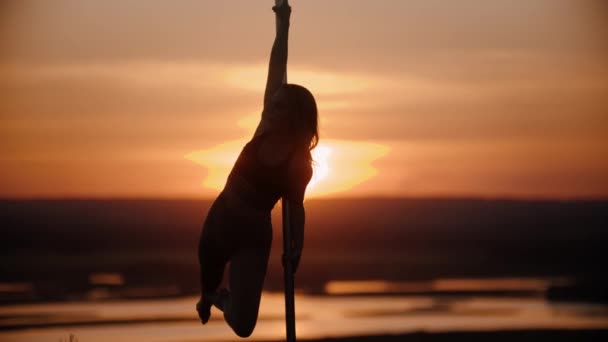 Femme en vêtements de sport ouverts dansant près du poteau sur le coucher du soleil à l'extérieur — Video