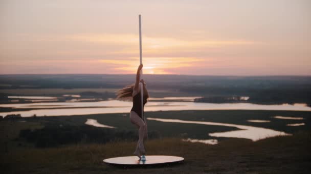 Sexig kvinna dansare i svart baddräkt dansar vid stolpen vid solnedgången — Stockvideo