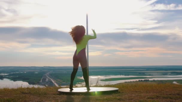 Pole dance sur la nature - sexy belle femme en maillot de bain jaune dansant par le poteau — Video