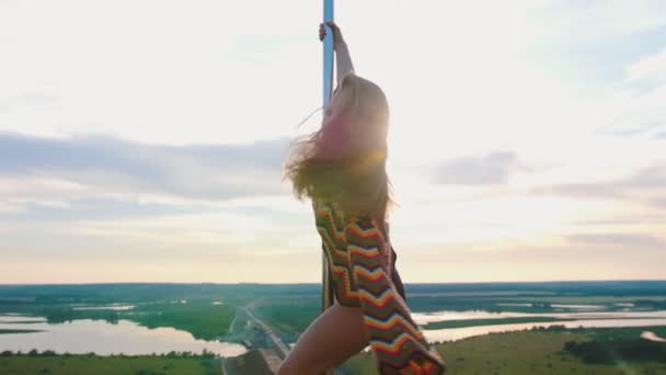 Pole Dance in der Natur - Frau im Badeanzug und bunt gestricktem Crop Top tanzt auf der Spitze der tanzenden Stange — Stockvideo