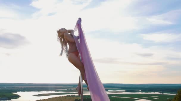 Pool dans op de natuur - vrouw met blauwe vlechten spinnen op de paal met roze sluier — Stockvideo