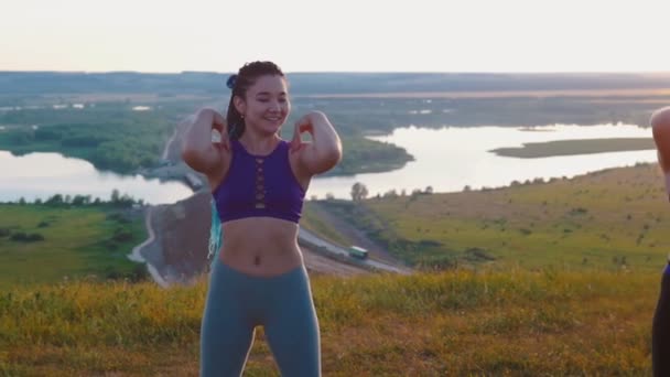 Фитнес на природе - три молодые женщины делают упражнения — стоковое видео