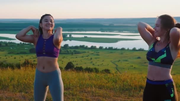 Fitness sulla natura - tre giovani donne che si scaldano le spalle — Video Stock