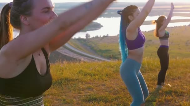 Doğa sporu - üç genç kadın yoga egzersizleri yapıyor. — Stok video