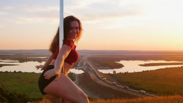 Pool dans op zonsondergang - jonge vrouw spinnen door de paal — Stockvideo