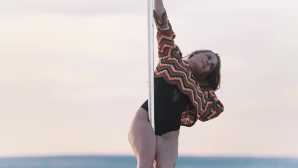 Pole Dance in der Natur - Frau in bunt gestricktem Crop Top hält sich an der Stange — Stockvideo