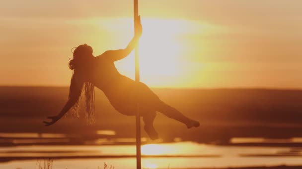 Pole dance na jasném západě slunce - akrobatická tanečnice — Stock video
