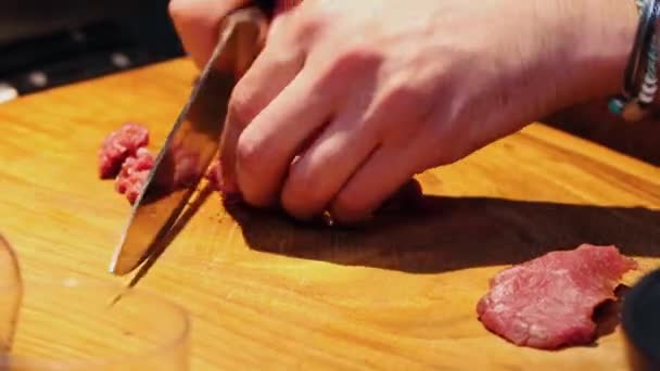Cocina del restaurante - chef cortando carne en trozos pequeños con cuchillo afilado — Vídeos de Stock