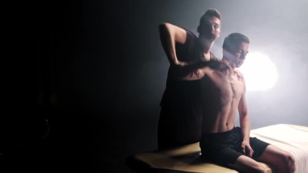 Massage sessie in rokerige studio - therapeut werken met zijn klanten handen en schouders — Stockvideo