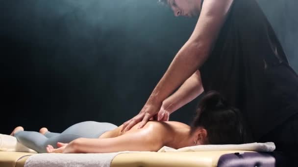 Mužský terapeut masíruje ženy zpět olejem — Stock video