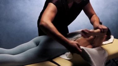 Stüdyoda masaj seansı. Terapist kadın vücuduna havlu koyuyor.