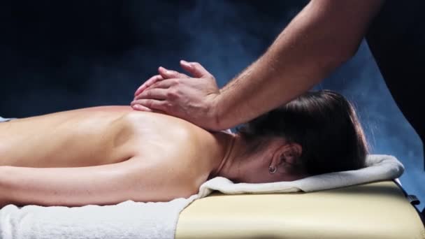 Massage sessie in donkere studio - therapeut masseren van de vrouwen terug en richt zich op de wervelkolom — Stockvideo