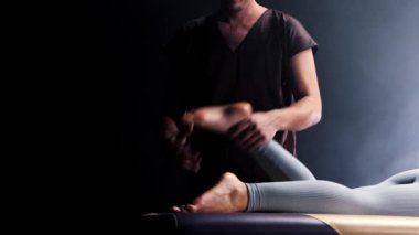 Masaj seansı. Erkek terapist odaya girer ve genç kadınların ayağına masaj yapmaya başlar.