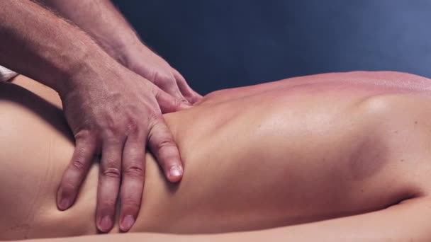 Sessão de massagem - terapeuta massagear as mulheres de volta enquanto ela está deitada em um sofá — Vídeo de Stock