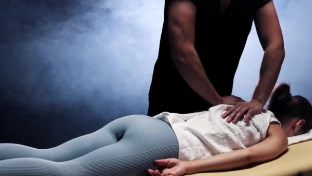 Sesión de masaje en el estudio - terapeuta masajeando a las mujeres sobre la toalla — Vídeo de stock